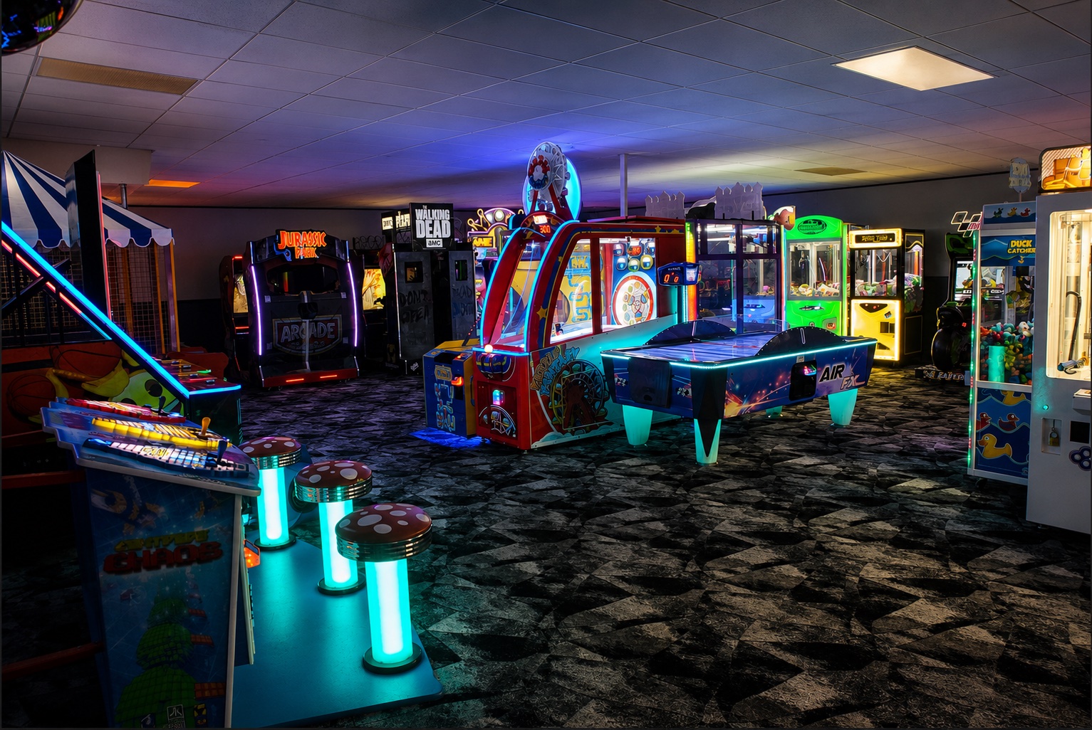 Neon-lit arcade with Jurassic Park, air hockey, skee-ball, claw machines, and ticket-redemption games